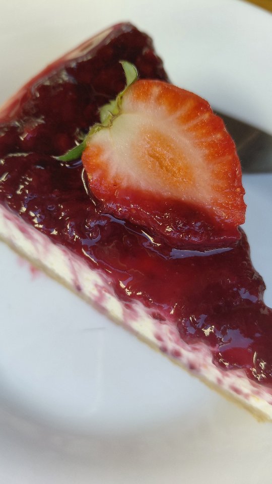 Fatia de cheesecake com calda artesanal de frutas vermelhas e morango