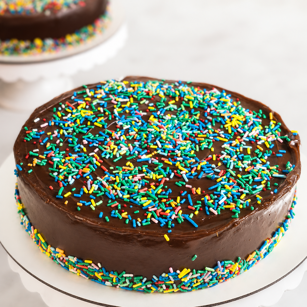 Bolo escolar baixo de chocolate com cobertura de brigadeiro e confeitos coloridos — foto confirmada pela Dulce